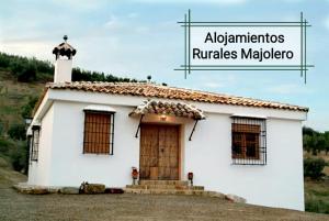 Castillo de LocubínCortijo Rural Majolero的上面有十字架的小白色房子