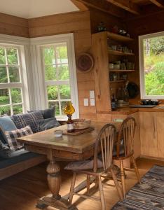 大堡礁岛Whalers Cottage的客厅配有木桌和椅子