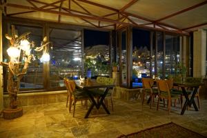 格雷梅Feel Cappadocia Stone House的一间带桌椅和窗户的用餐室
