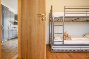 奈达Kopu Vetrunges - Nida Apartments的带两张双层床和一扇门的房间