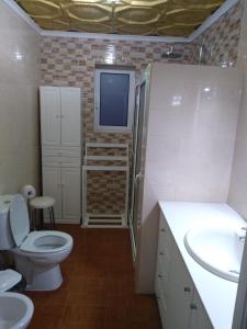 BiscoitosVivenda "Porto de Abrigo"的一间带卫生间的浴室和墙上的电视