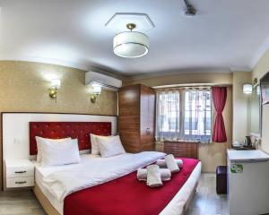 伊斯坦布尔Cihangir Palace Hotel的一间卧室配有一张带红色毯子的大床