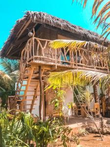 锡基霍尔Mandala Tribe Treehouses的海滩上带茅草屋顶的房子