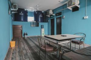 雅加达RedDoorz near RSUD Koja的一间拥有蓝色墙壁和桌椅的用餐室