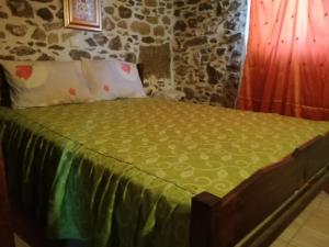 KapetanianáThe Rock的一张带绿色被子和枕头的床