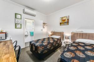 纳拉库特休闲汽车旅馆 的酒店客房设有两张床、一张桌子和一间厨房。
