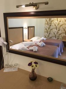利吉亚阿夫拉酒店的卧室内2张床的镜子反射