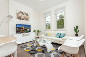 悉尼STUNNING SYDNEY HOME 4的白色的客厅配有白色的沙发和桌子