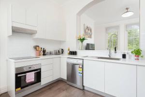 悉尼STUNNING SYDNEY HOME 4的白色的厨房配有水槽和洗碗机