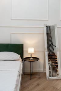 第比利斯Shota Rustaveli Aparthotel的一间卧室配有一张床和一张带台灯的桌子