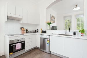 悉尼STUNNING SYDNEY HOME 10的白色的厨房配有水槽和洗碗机