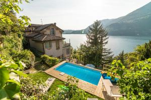 布里维奥B&B Villa Costanza的水边的一座房子,有一个游泳池