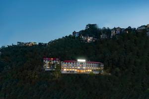西姆拉Larisa Shimla的山顶上一座灯光明亮的建筑