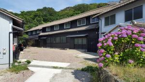 京丹后市Asobi Lodge的前面一排种着紫色花的房屋