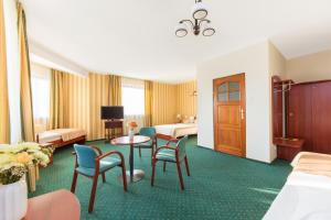 华沙阿卡迪亚酒店的酒店客房带一张床、一张桌子和椅子