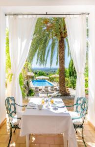坎帕内特Son Colom Turismo de interior Bed & Breakfast的棕榈树庭院里的白色桌椅