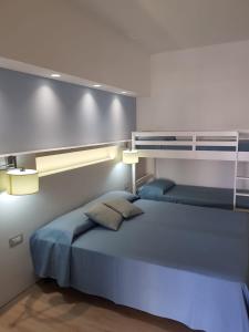圣维托罗卡波佩尔拉盖亚酒店的一间卧室配有一张带蓝色床单的大床