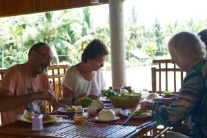 Nguyệt HạngTra Vinh Lodge的一群坐在桌子旁吃食物的人