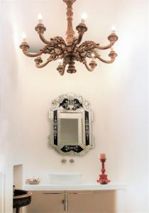 锡拉库扎Reggia del Saraceno的吊灯悬挂在浴室水槽上,配有镜子