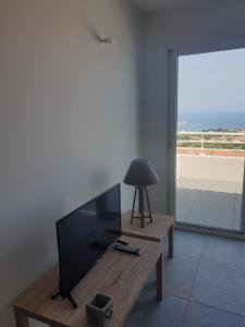 蒙蒂塞洛Corsica Résidence Galitello的客厅配有平面电视和桌子。