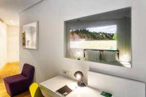 马德里普拉多23酒店的一间设有镜子、一张桌子和一把椅子的客房