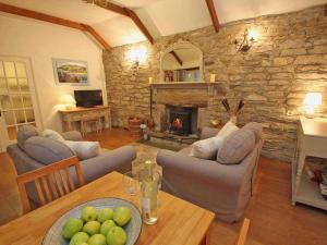 博德明Dairy Cottage的客厅配有桌子和石头壁炉