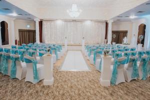 阿斯克Cwrt Bleddyn Hotel & Spa的宴会厅配有蓝色和白色的椅子和桌子