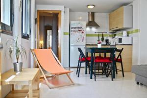 加的斯Apartamento PUERTA-CALETA by Cadiz4Rentals的小厨房以及带桌椅的用餐室。