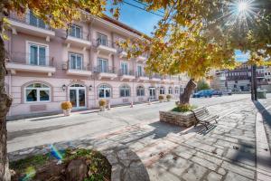 卡斯托里亚Hotel Kastoria in Kastoria City的一条城市街道上的粉红色大建筑