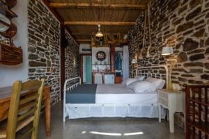 TriovasálosMilos Dream Life的卧室配有一张石墙床