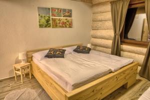 塔莱Zruby Pod Chopkom的一间卧室配有一张带两个枕头的木床
