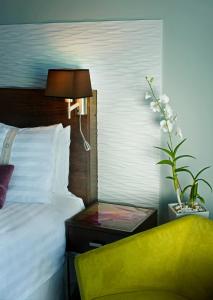 圣多明各Holiday Inn Santo Domingo, an IHG Hotel的一间卧室配有一张床和一张带台灯的桌子