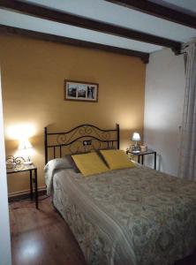 SotoserranoCasa Rural El Arroyo的一间卧室配有一张大床和两张桌子