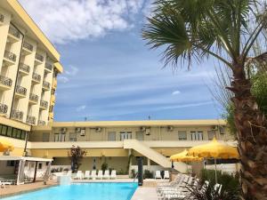 里米尼蒙马特公寓酒店的享有酒店游泳池和棕榈树的景色