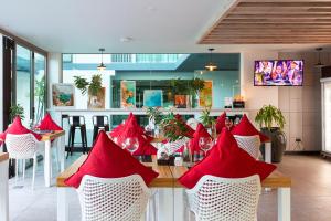 邦涛海滩Oceanstone by Holy Cow, 2-BR, 90 m2, pool view的一间餐厅,餐桌上摆放着红色餐巾