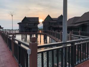 珍南海滩Langkawi Lagoon Resort Water Chalet的水面上一些建筑物旁边的围栏