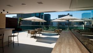 里约热内卢美洲格拉纳达酒店的一个带桌椅和遮阳伞的屋顶露台