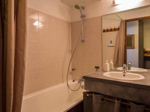 佩塞克鲁瓦34 Grande Ourse Vallandry - Les Arcs - Paradiski的浴室配有水槽、淋浴和浴缸。