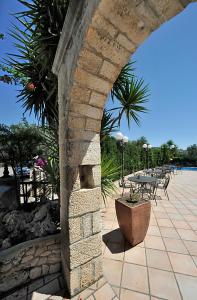 马蒂纳塔阿潘尼斯塔酒店的庭院内带桌椅的石拱门