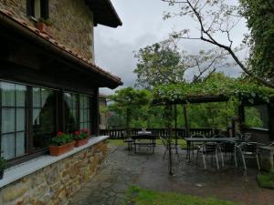 Axpe de BusturiaAgroturismo Iturbe的毗邻大楼的带桌椅的天井