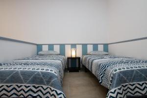 罗萨里奥港Atlantic Loft的蓝色和白色条纹间内的两张床