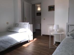 圣洛伦索-德埃斯科里亚尔Apartamento en Centro Historico de San Lorenzo de El Escorial的一间卧室配有两张床和一张带台灯的桌子
