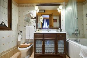 Mondéjar卡瑟纳托雷斯酒店的浴室配有卫生间、盥洗盆和浴缸。