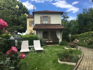 奥瓦达Il Borgo Delle Grazie的院子里两把白色椅子的房子
