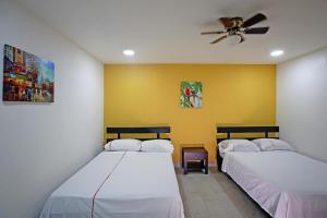 圣何塞Hotel San José的配有吊扇的客房内的两张床