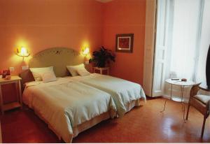 塞哥维亚福尔诺斯旅馆的一间卧室配有一张带白色床单的大床