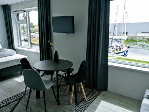 莱米尔Marina Strand Appartement Lemmer的客房设有桌椅和窗户。
