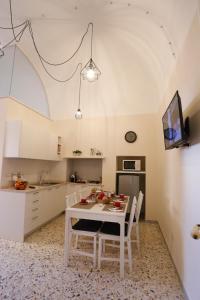 普蒂尼亚诺CASA CAIROLI PUTIGNANO的厨房配有白色的桌椅