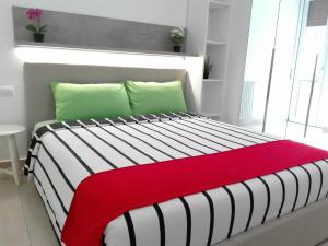 米兰Rogoredo Milan Apartments的一张带红色毯子和绿色枕头的床