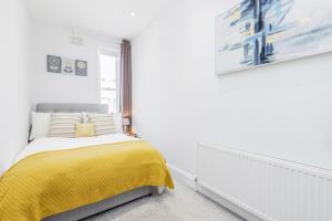 伦敦2-bed Notting Hill / Portobello的一间卧室配有一张黄色毯子床